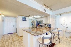 a kitchen with a counter and some chairs in a room at Sunset Shores in St Pete Beach