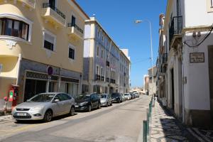 een rij auto's geparkeerd op een straat met gebouwen bij Yellow Inn Aveiro in Aveiro