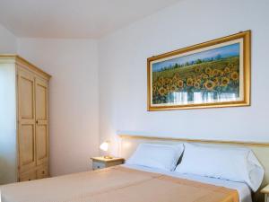 1 dormitorio con 1 cama con una pintura en la pared en Hotel Donatella, en Posada