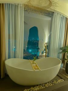 a white bath tub in a bathroom with a window at Cine Homestay - Căn hộ cao cấp Ecopark Hải Dương in Hải Dương