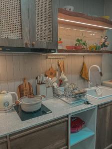 a kitchen with a counter top with a sink and some dishes at Cine Homestay - Căn hộ cao cấp Ecopark Hải Dương in Hải Dương