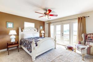 een slaapkamer met een bed en een plafondventilator bij Lake June in Lake Placid