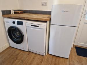 um frigorífico branco e uma máquina de lavar roupa na cozinha em West Beck House - Newcastle 5 em North Shields