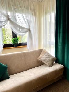 a couch sitting in front of a window at AgroDomek in Rzepiska