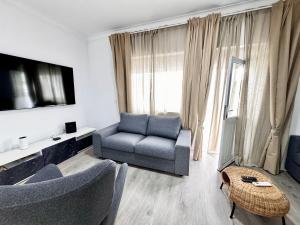 ein Wohnzimmer mit Sofa und Fernseher in der Unterkunft Caparica Villa blue beach in Costa da Caparica