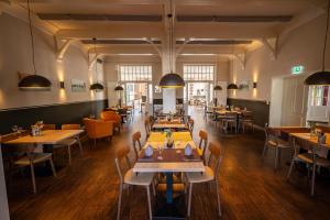 a restaurant with tables and chairs in a room at Hotel Alter Kreisbahnhof in Schleswig