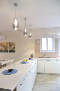 a kitchen with white cabinets and a white counter top at Varkiza seafront dream Appartment in Varkiza