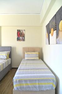 a bedroom with two beds and paintings on the wall at Varkiza seafront dream Appartment in Varkiza