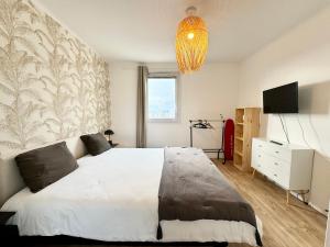 een slaapkamer met een groot wit bed en een kroonluchter bij Exceptionnel ! T3 de standing - Rooftop - Jacuzzi in Lorient