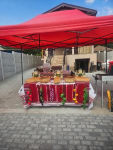 uma tenda vermelha com uma mesa com comida em Casa Rustica Cernica em Cernica