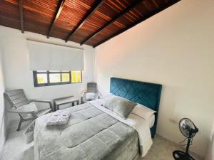 a bedroom with a large bed and a chair at Casa Hotel Camino Real in Guadalupe