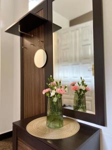 due vasi con fiori su un tavolo di fronte a uno specchio di AgroDomek Rzepiska a Rzepiska