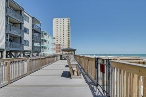 a boardwalk along a beach with buildings and the ocean at Coastal Condo on Beach with Community Pool Access! in Myrtle Beach