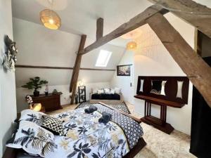 a bedroom with a bed and a piano at La P'tite maison Les Tourelles in Caffiers