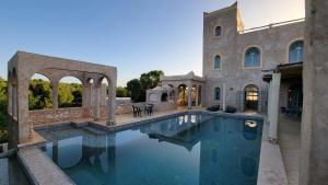 a large swimming pool in a house with a mansion at Dar Ez-zine in Ounara