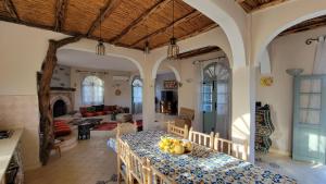 a kitchen and living room with a table with fruit on it at Dar Ez-zine in Ounara