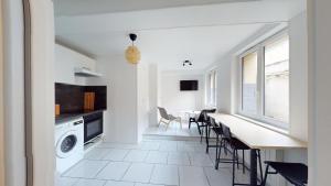 een keuken en eetkamer met een tafel en stoelen bij Immeuble COTY Jacuzzi studios et chambres in Le Havre