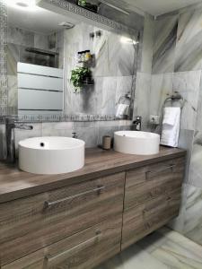 Baño con 2 lavabos y espejo en Apartamento Las Abejeras en Estepona