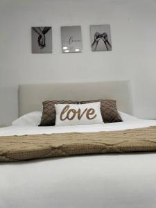 Una cama con una almohada con la palabra amor en ella en Apartamento Las Abejeras en Estepona