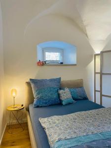 sypialnia z łóżkiem z niebieskimi poduszkami i lustrem w obiekcie schloss1 w mieście Selb