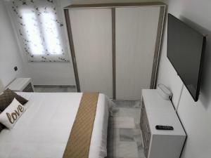 1 dormitorio con cama, mesa y ventana en Apartamento Las Abejeras, en Estepona