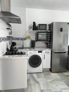 y cocina con lavadora y nevera. en Apartamento Las Abejeras en Estepona