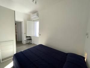 a bedroom with a blue bed in a white room at Villa Maris - accesso diretto alla spiaggia in Santa Marina Salina