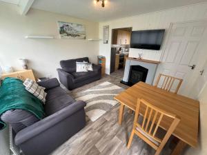 a living room with a couch and a table at Chalet 192, Hemsby - Two bed chalet, sleeps 5, pet friendly, bed linen and towels included in Hemsby