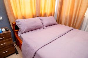 a small bedroom with a bed and a dresser at Studio cosy et agréable in Lomé