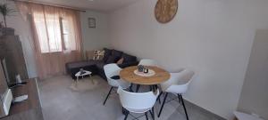 een woonkamer met een houten tafel en witte stoelen bij Apartment Olive in Kaštela