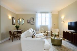 The Manor Gardens Retreat - Captivating 1BDR Flat with Terrace في لندن: غرفة معيشة مع أريكة بيضاء وتلفزيون