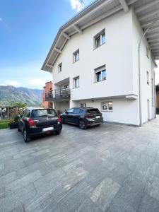 two cars parked in front of a building at Terme Apartment Levico in Levico Terme