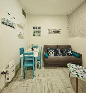 ein Wohnzimmer mit einem Sofa und einem Tisch in der Unterkunft The Sailors House Ha in Cádiz
