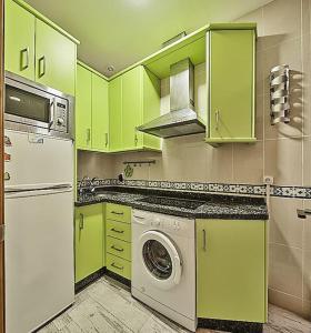 eine Küche mit grünen Schränken und einer Waschmaschine in der Unterkunft The Sailors House Ha in Cádiz