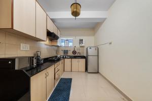 a kitchen with wooden cabinets and a refrigerator at House of 2 Tress Penthouse in Bangalore