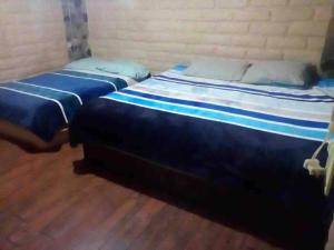 2 Betten nebeneinander in einem Zimmer in der Unterkunft Cabaña Los Hernández in Arteaga