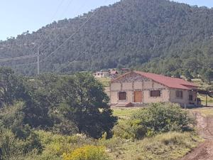a house in a field with a mountain in the background at Cabaña Los Hernández in Arteaga