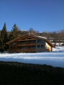 a large wooden house with snow in front of it at Chalet Apalosa - Montvalezan, La Rosière in Montvalezan