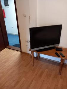 Une télévision à écran plat est installée au-dessus d'une table en bois. dans l'établissement Hostel Wien, à Novi Pazar