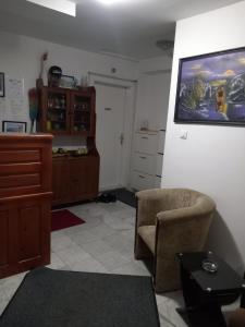 a living room with a chair and a painting on the wall at Hostel Wien in Novi Pazar
