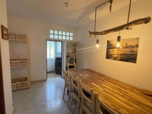 Happy Hostel Sagres في Raposeira: غرفة طعام مع طاولة وكراسي خشبية