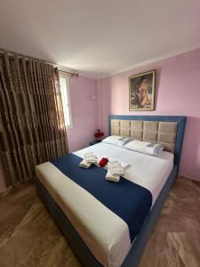 1 dormitorio con 1 cama grande y toallas. en Selami Sea View Apartments, en Lukovë