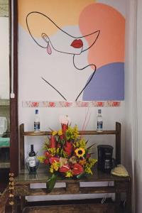 a vase of flowers on a table with a painting at hostal el gran amparo in Sevilla