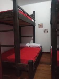 1 dormitorio con 2 literas con sábanas rojas en hostal el gran amparo en Sevilla