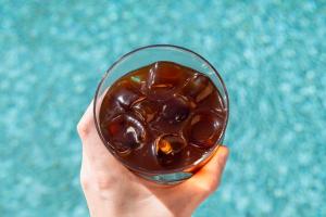 a hand holding a glass filled with chocolate at Hotel Shoshana - Adults Only in Eilat