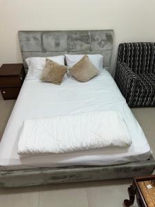a bed with white sheets and pillows in a room at R2)Sweet Home fantastic city and sea view at beachإطلالة رائعة على المدينة والبحر على الشاطئ in Ajman 