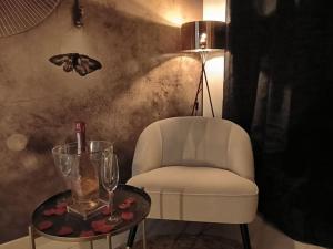 a chair and a table with a butterfly on the wall at LOVE ROOM - Amour Chic et Intime in Montbrison +3 photos