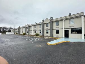 a parking lot in front of a large building at Suburban Studios Chester I-95 in Chester