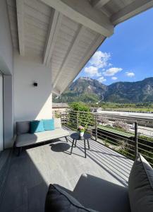 a balcony with a couch and a table and mountains at Terme Apartment Levico in Levico Terme