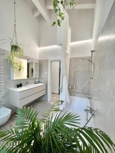 ein Badezimmer mit einer weißen Badewanne und einem Waschbecken in der Unterkunft Terme Apartment Levico in Levico Terme